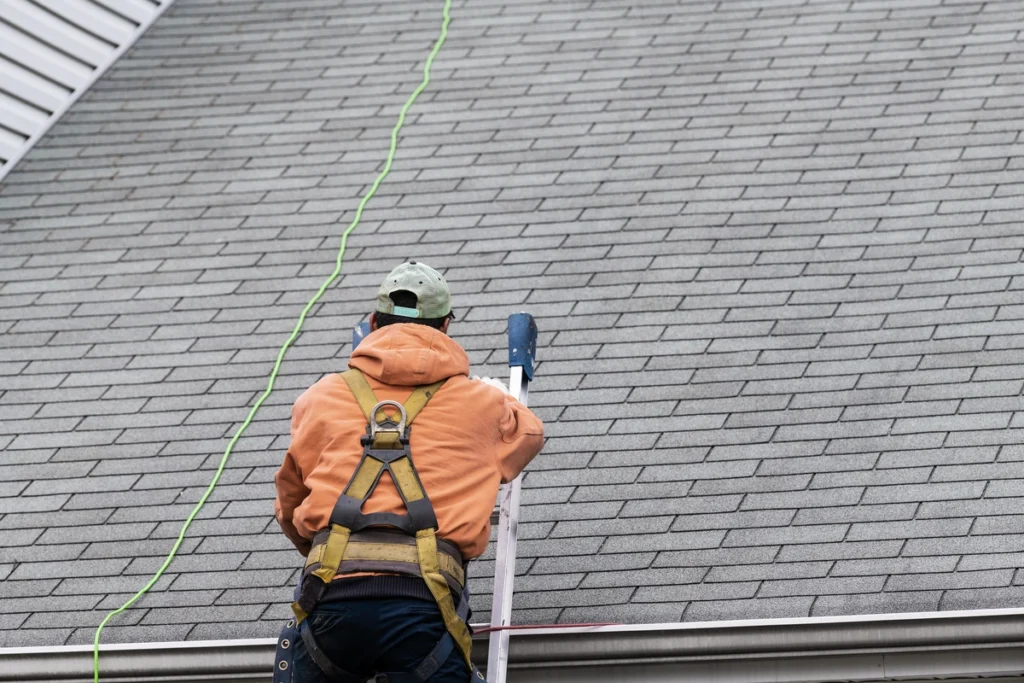 roof inspection checklist-tech climbing ladder to the roof for inspection